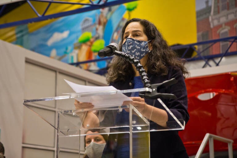 Dr. Cheryl Bettigole speaks from a podium while wearing a face mask