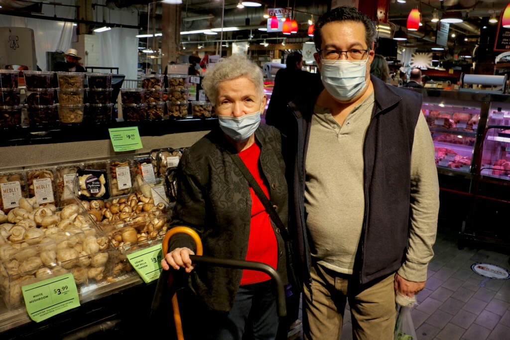 Lenore Gorenstein stands next to her son, Joel, at a produce market