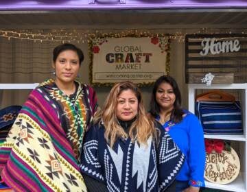 Tania Greene, Reyna Navarro and Tania León are selling at the Christmas Village for the first time. (Elizabeth Estrada/WHYY)