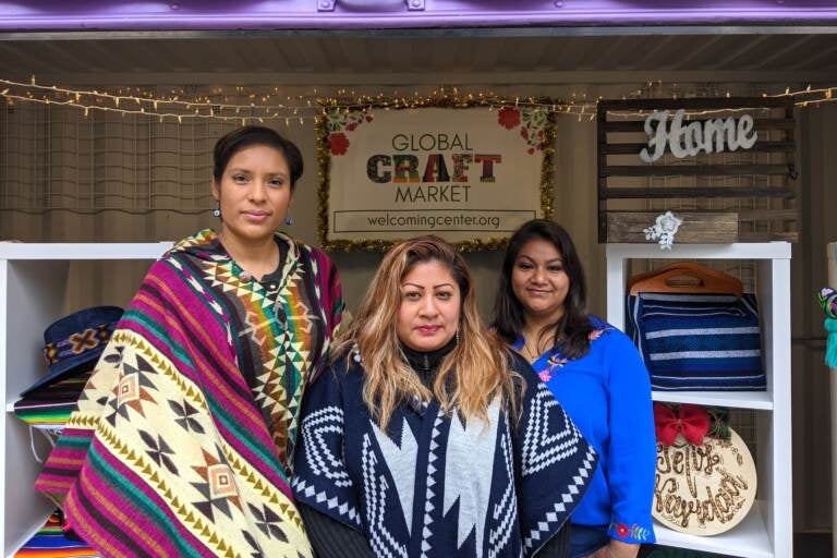 Tania Greene, Reyna Navarro and Tania León are selling at the Christmas Village for the first time. (Elizabeth Estrada/WHYY)