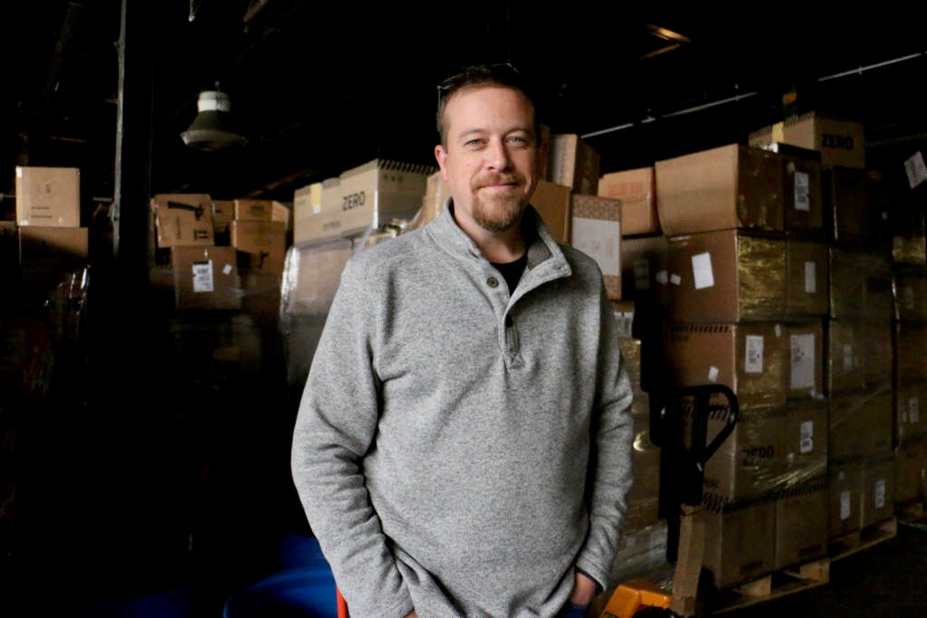 Kevin Flynn poses for a photo inside a warehouse