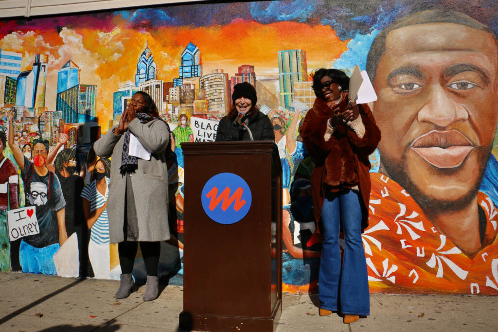 Jane Golden speaks from a podium at a mural unveiling