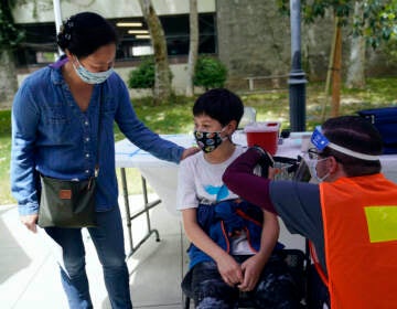 Colin Sweeney gets a COVID-19 vaccine, with his mother to his right