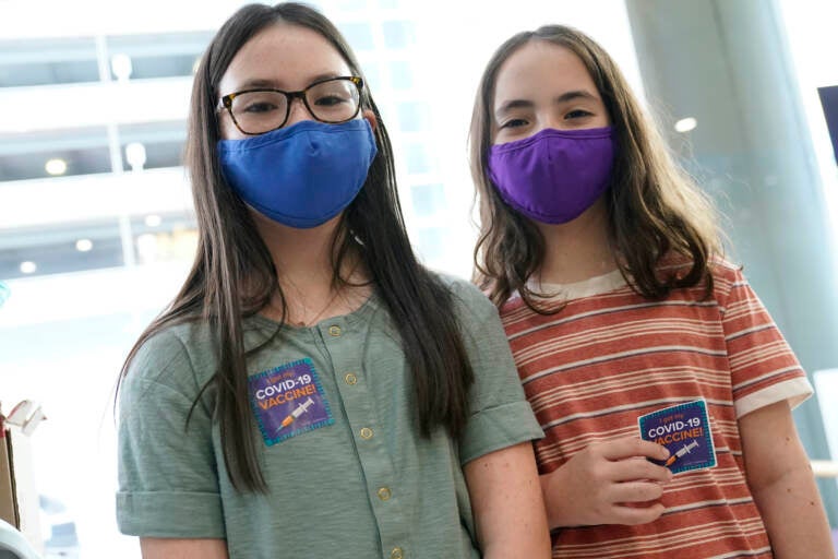 Ryann and Jamie Onofrio Franceschini pose for a photo with COVID-19 vaccine stickers while wearing face masks