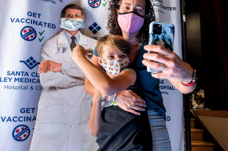 Finn Washburn shows his vaccination site as mom Kate Elsley takes a photo