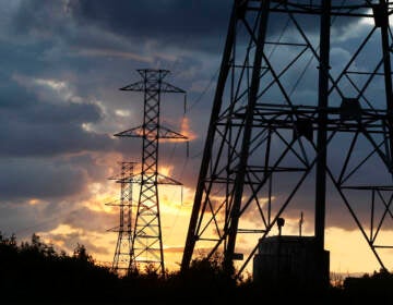 Electrical power generation lines are seen below storm clouds in a rural field near Newtown, Pa. (AP Photo/Mel Evans)