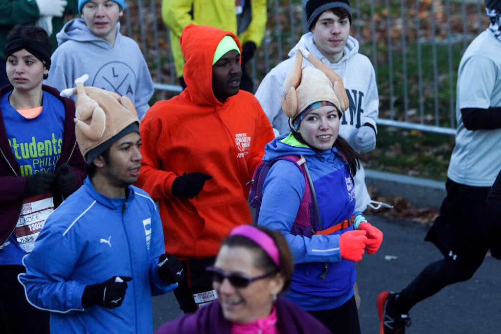 Two runners wear turkey hats as they make their way down the Benjamin Franklin Parkway in Philadelphia at the start of the Philadelphia Marathon, Sunday Nov. 20, 2016