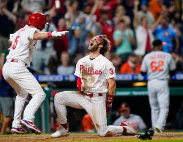 Philadelphia Phillies' Bryce Harper (3) and Andrew Knapp (5) celebrate after Harper scored the game-winning run on a two-run triple by J.T. Realmuto during the 10th inning of an interleague baseball game against the Baltimore Orioles, Tuesday, Sept. 21, 2021, in Philadelphia