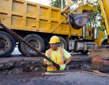 A worker removes an old water pipe from underneath the street before replacing it with new copper pipe in Newark, N.J., Thursday, Oct. 21, 2021. (AP Photo/Seth Wenig)