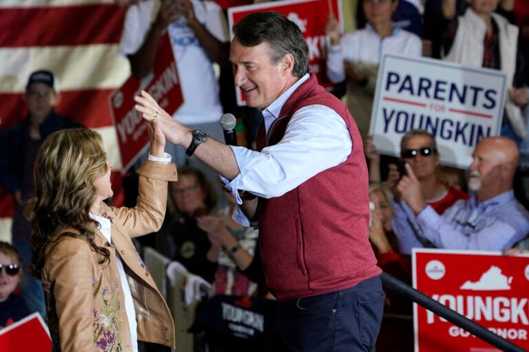 Republican gubernatorial candidate Glenn Youngkin, right, gives his wife Suzanne, a high five during a rally in Chesterfield, Va., Monday, Nov. 1, 2021
