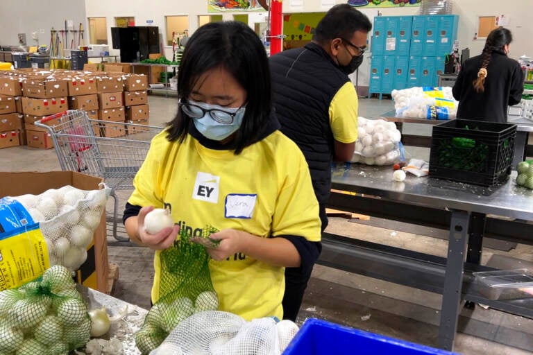 Workers pack onions at a food bank.