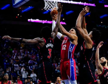 Philadelphia 76ers' Tobias Harris (12) goes up for a shot against Toronto Raptors' OG Anunoby (3), Scottie Barnes (4) and Fred VanVleet (23) during the second half of an NBA basketball game, Thursday, Nov. 11, 2021, in Philadelphia