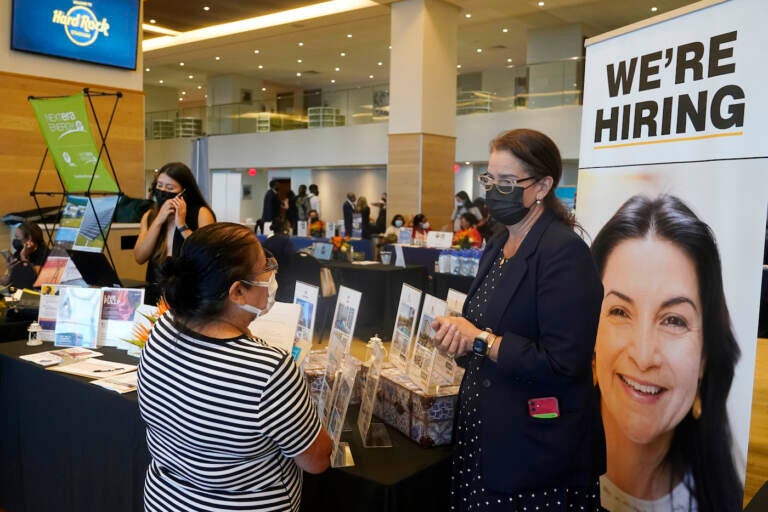 FILE - Marriott human resources recruiter Mariela Cuevas, left, talks to Lisbet Oliveros, during a job fair at Hard Rock Stadium, Friday, Sept. 3, 2021, in Miami Gardens, Fla.  Americans quit their jobs at a record pace for the second straight month in September, while businesses and other employers continued to post a near-record number of available jobs.  (AP Photo/Marta Lavandier, File)