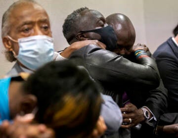 Ahmaud Arbery's father Marcus Arbery, center, his hugged by his attorney Benjamin Crump after the jury convicted Travis McMichael in the Glynn County Courthouse, Wednesday, Nov. 24, 2021, in Brunswick, Ga.  Greg McMichael and his son, Travis McMichael, and a neighbor, William 