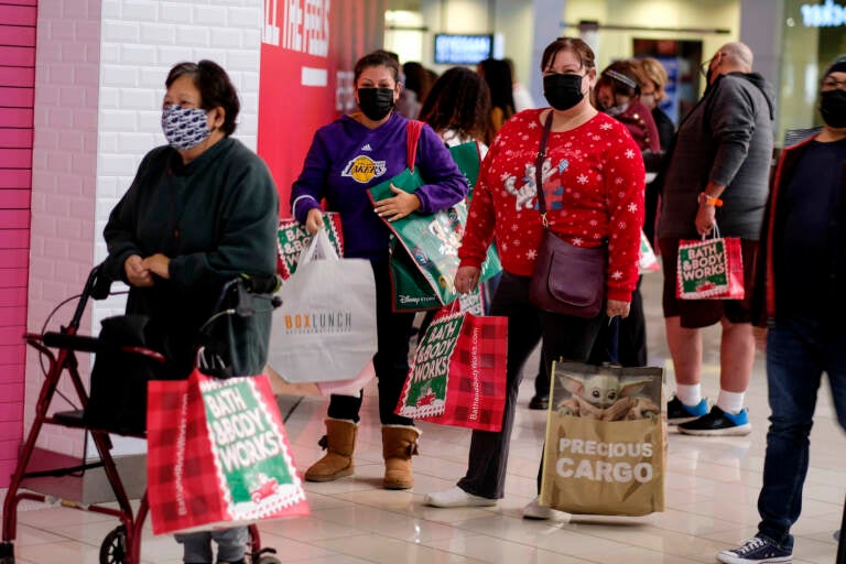 Black Friday shoppers wearing face masks wait in line to enter a store at the Glendale Galleria in Glendale, Calif., Friday, Nov. 27, 2020. (AP Photo/Ringo H.W. Chiu)