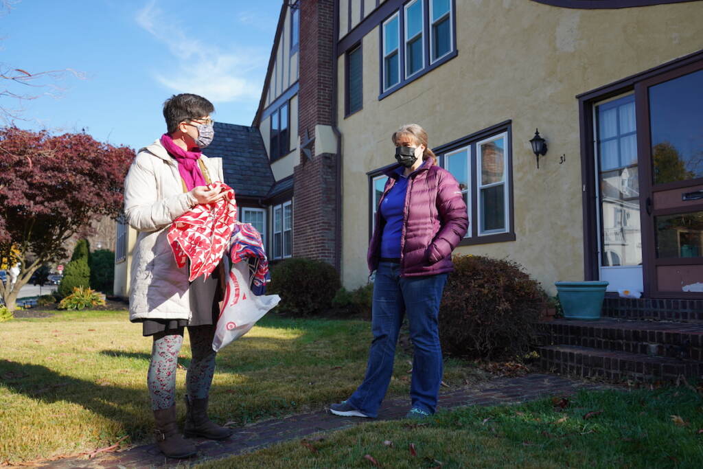 Anna Gavin (L) makes a morning pickup from Diane Echternach, who is in the process of cleaning out her mother-in-law's home in Lansdowne.