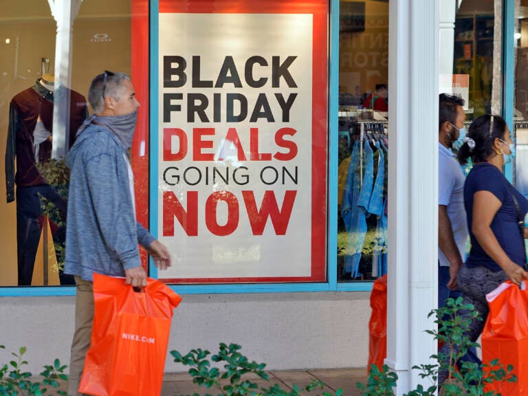 Shoppers wear protective face masks as they look for Black Friday deals at the Ellenton Premium Outlet stores Friday, Nov. 27, 2020, in Ellenton, Fla. (AP Photo/Chris O'Meara, file)