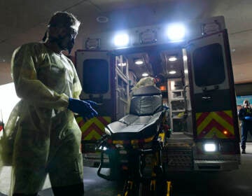 Firefighter Chris Herrington begins to take off his personal protective equipment as he and his partner John Cronin, in ambulance, wait for a 