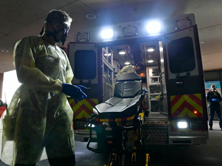 Firefighter Chris Herrington begins to take off his personal protective equipment as he and his partner John Cronin, in ambulance, wait for a 