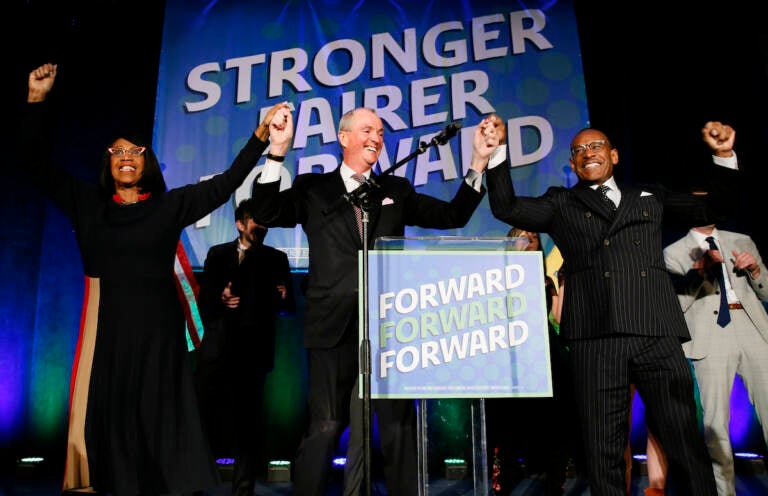 Lt. Gov. Sheila Oliver, left, New Jersey Governor, Phil Murphy center, and LeRoy Jones, chairman of the state's Democratic committee, right, celebrate at Convention Hall after winning gubernatorial race against Jack Ciattarelli. 
Wednesday, Nov. 3, 2021, in Asbury Park, N.J. 
(AP Photo/Noah K. Murray)