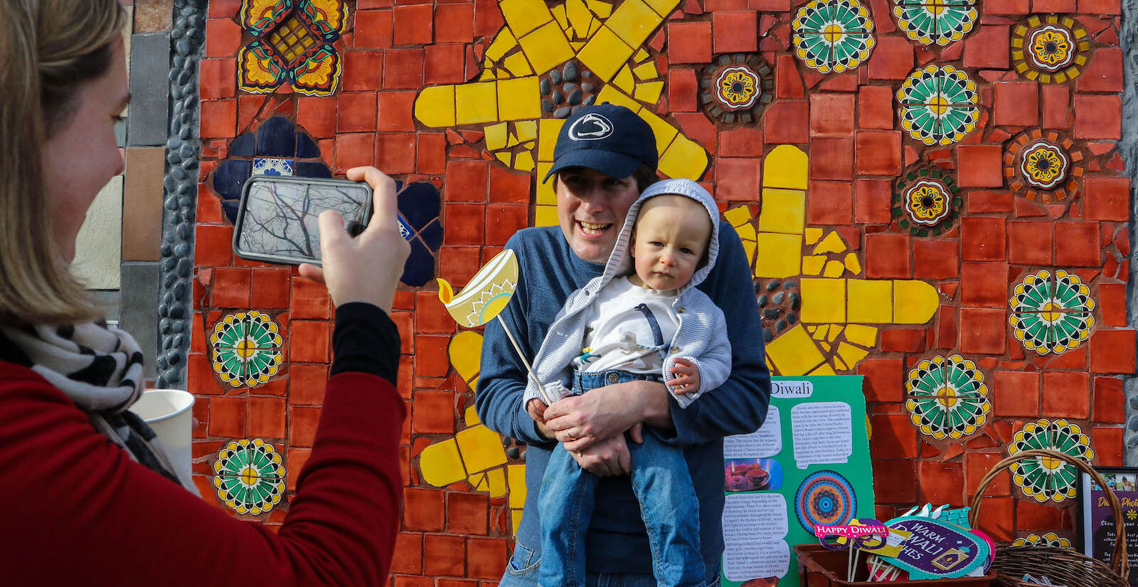 Sarah Beltz taking a photo of John Paul and Eli Johnson, of Doylestown at the first annual Diwali festival in Doylestown on Nov. 7, 2021. (Daniella Heminghaus for WHYY)