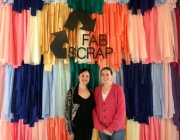 FABSCRAP co-founder and creative director Camille Tagle and founder and CEO Jessica Schreiber (L-R) stand in front of a fabric wall outside of the Philadelphia location