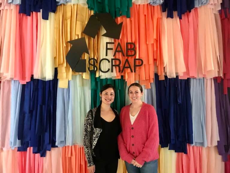 FABSCRAP co-founder and creative director Camille Tagle and founder and CEO Jessica Schreiber (L-R) stand in front of a fabric wall outside of the Philadelphia location