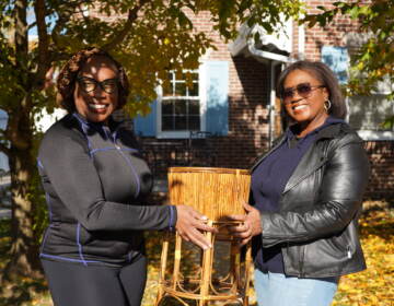 Jessica Pointer (L) accepts a gift, a plant stand, from Lisa Ivery (R) on a sunny, fall morning.