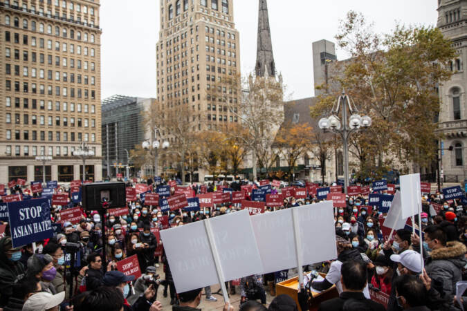 Protesters gather at Thomas Paine Plaza, with signs visible that say, 