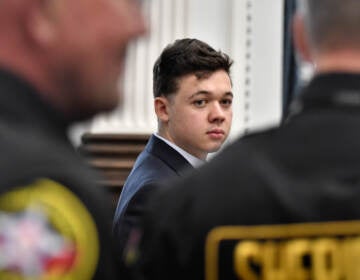 Kyle Rittenhouse, center, looks back as Kenosha County Sheriff's deputies enter the courtroom