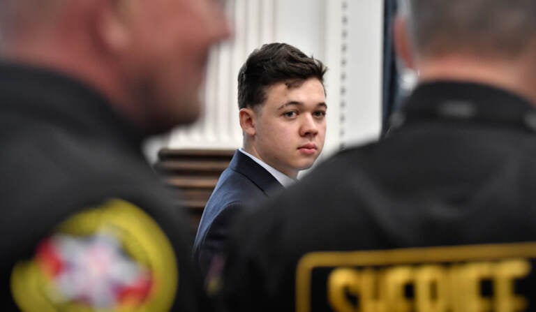 Kyle Rittenhouse, center, looks back as Kenosha County Sheriff's deputies enter the courtroom