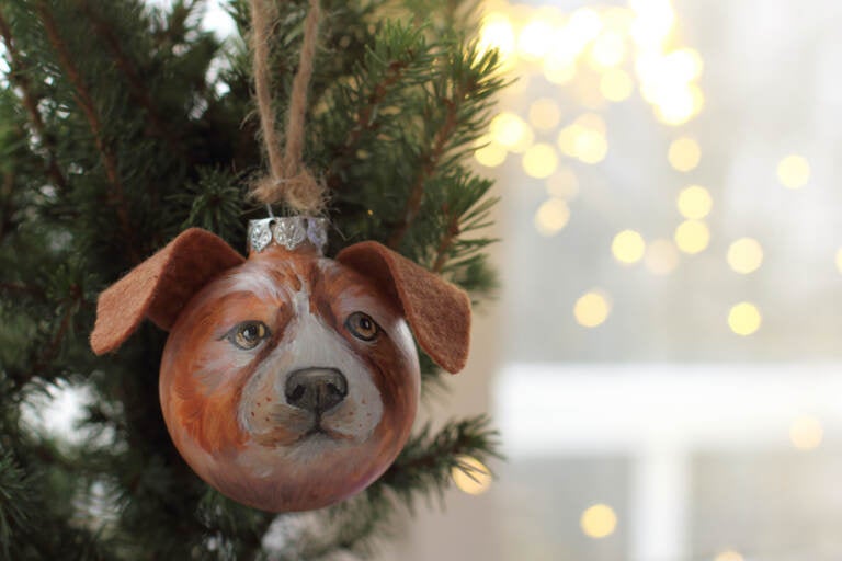 A Christmas glass ball decoration depicting a dog's face