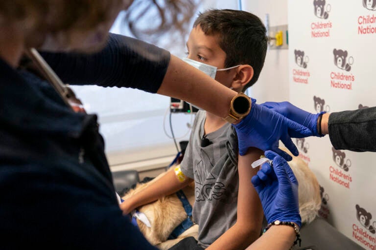 Santiago Esparza is vaccinated by a nurse