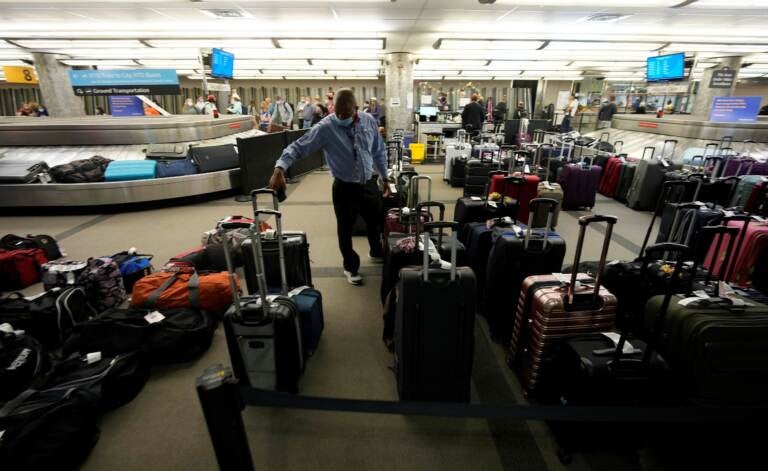 Unclaimed baggages wells up between carousels for passengers arriving on Southwest Airlines flights at Denver International Airport late Sunday, Oct. 10, 2021, in Denver. Southwest Airlines canceled hundreds of flights over the weekend, blaming the woes on air traffic control issues and weather. (AP Photo/David Zalubowski)