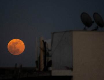 The super blood noon rises over a residential area in New Delhi during a total lunar eclipse in May. (Jewel Samad/AFP via Getty Images)