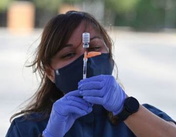 A nurse fills a syringe with Pfizer-BioNTech's COVID-19 vaccine