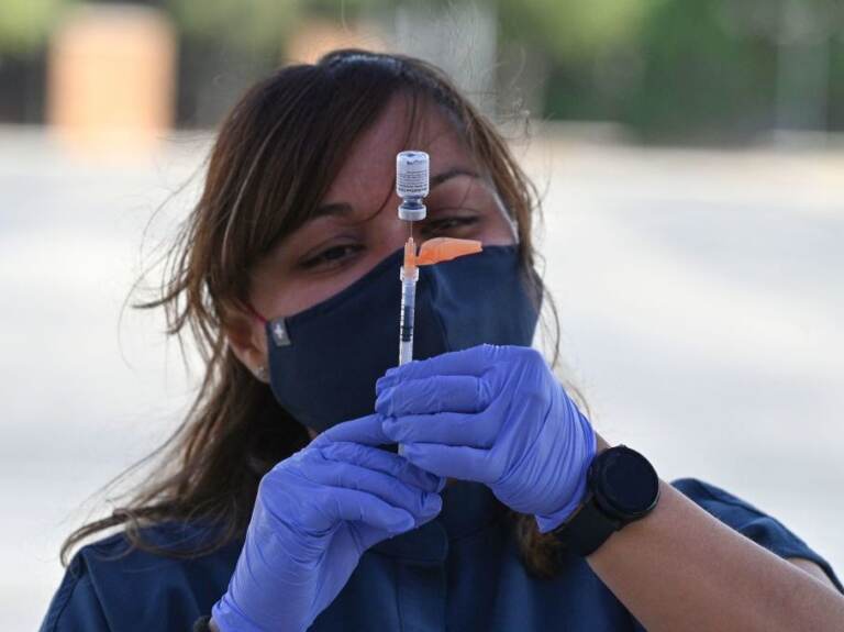 A nurse fills a syringe with Pfizer-BioNTech's COVID-19 vaccine