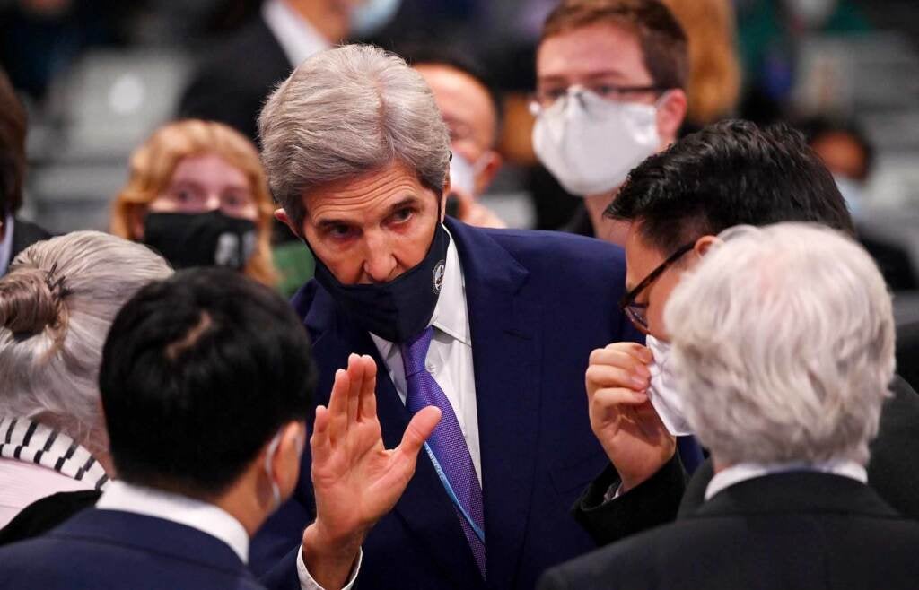 John Kerry gestures while speaking, and wearing a mask, at a UN summit