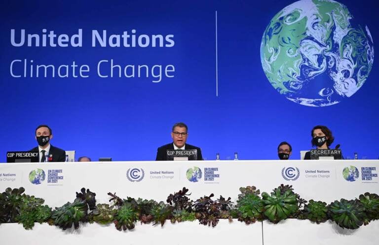 President Alok Sharma (C) speaks at a table at a UN conference