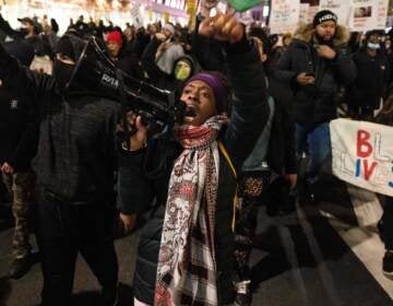 A demonstrator raises her fist while marching on the street during a protest against the Kyle Rittenhouse not-guilty verdict near the Barclays Center in New York City on Friday. A demonstrator raises her fist while marching on the street during a protest against the Kyle Rittenhouse not-guilty verdict near the Barclays Center in New York on November 19, 2021. (Photo by YUKI IWAMURA/AFP via Getty Images)