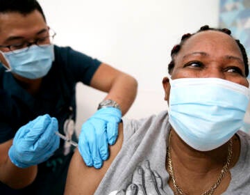 An in-home care worker receives her first dose of the COVID-19 vaccine in February in Los Angeles, Calif.
(Mario Tama/Getty Images)