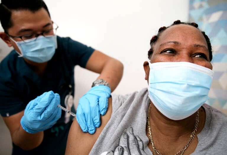 An in-home care worker receives her first dose of the COVID-19 vaccine in February in Los Angeles, Calif.
(Mario Tama/Getty Images)