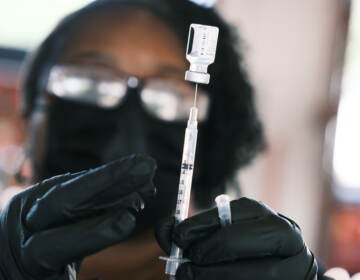 A person prepares to administer a Pfizer COVID vaccine at a clinic in Ferguson, Missouri in August 2021. Merriam-Webster has chosen 