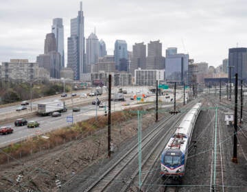 An Amtrak train departs 30th Street Station moving parallel to motor vehicle traffic on Interstate 76 in Philadelphia. (AP Photo/Matt Rourke)