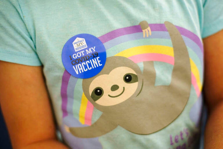 A closeup of a child's t-shirt, with a sticker visible that says, 