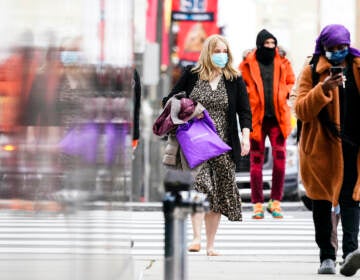 People wearing face masks walk through Philadelphia