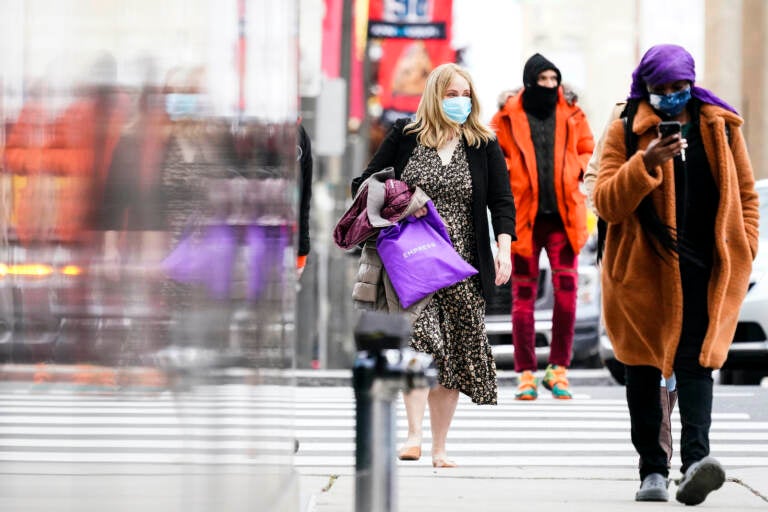 People wearing face masks walk through Philadelphia