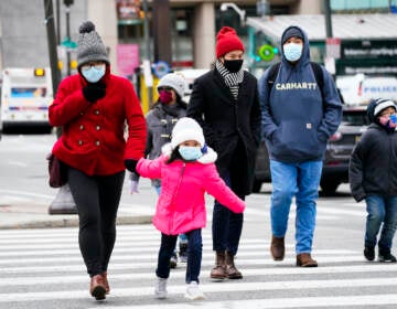 People wearing face masks walk through Philadelphia