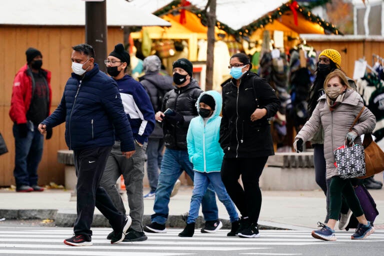 People wearing face masks walk through Philadelphia