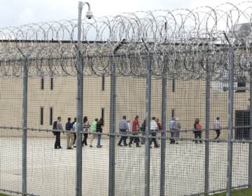 People walk on a tour of the West section of the State Correctional Institution at Phoenix in Collegeville, Pa